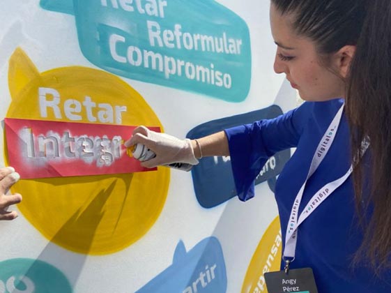 imagen de mujer pintando con un aerosol palabras en un muro en el Summit 2022 de DigitalES