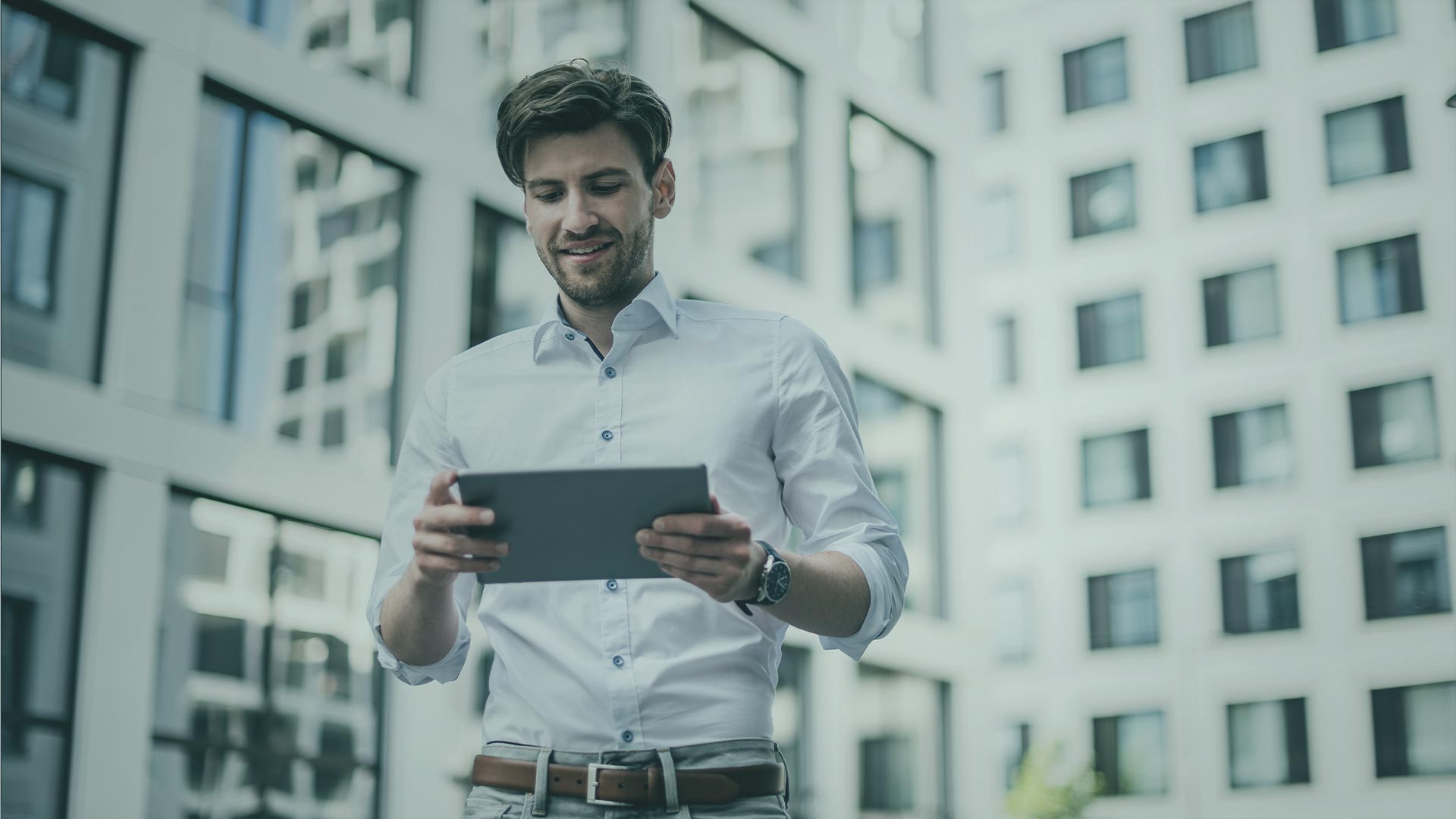 Hombre viendo una tablet sonriendo