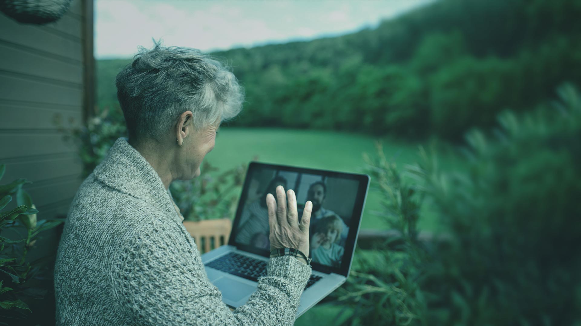 Abuela saludando a su familia a través de una laptop