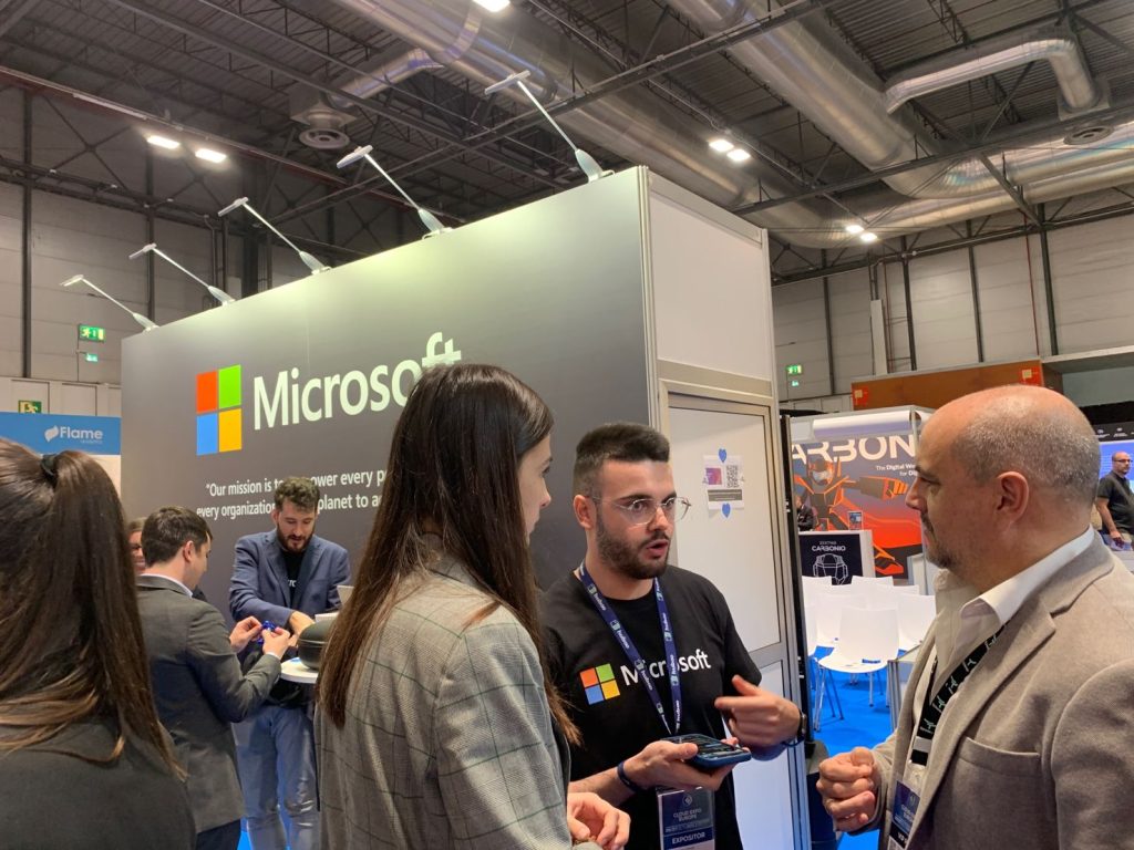 Participantes Madrid Tech Show 2022 hablando con alguien del equipo de Microsoft